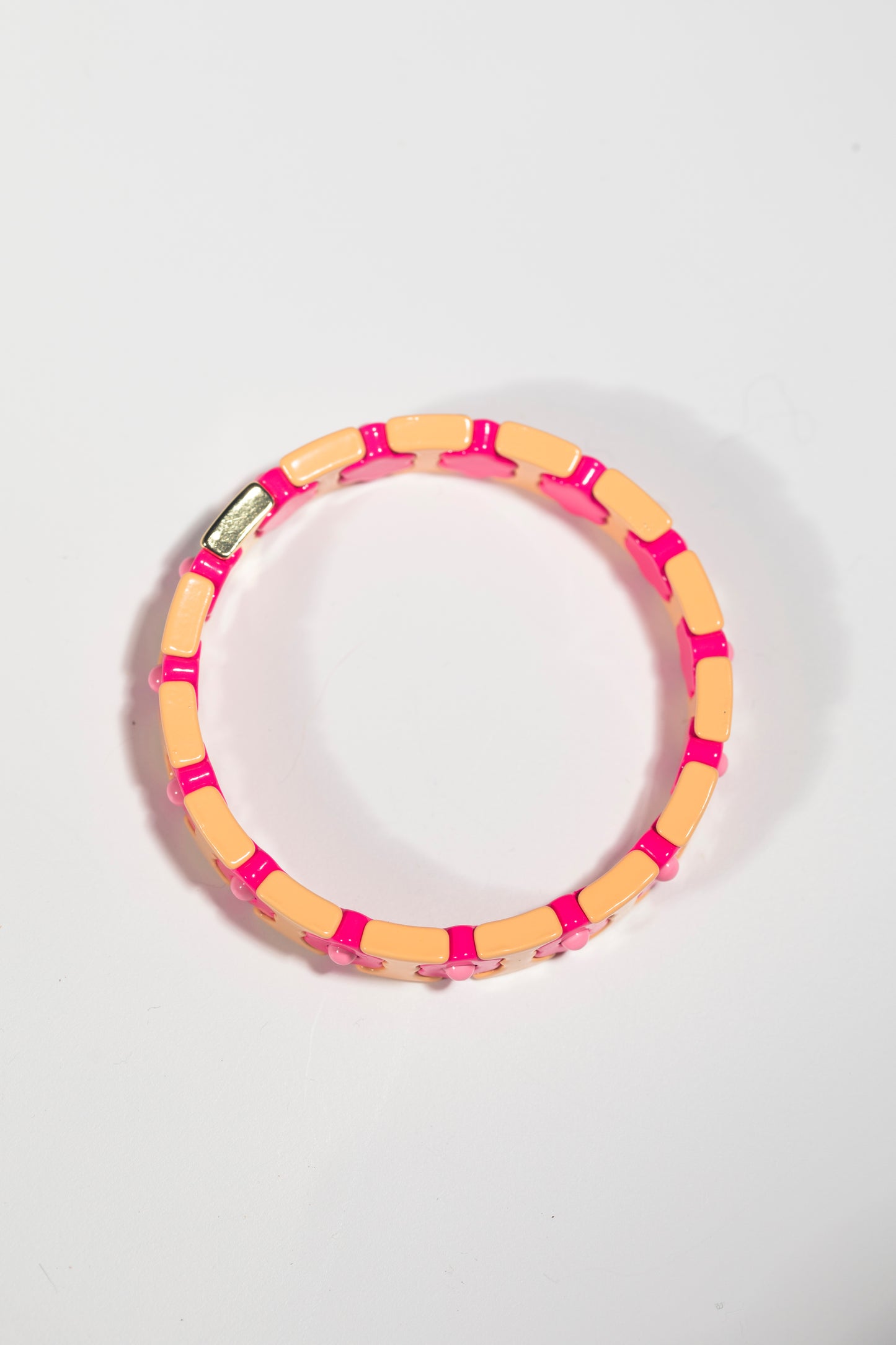 Elastic tile bracelet with alternating peach and hot pink tiles, gold connector, photographed flat on white background