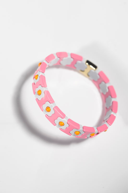 A pink and white enamel bracelet with a repeating pattern of sunny side up eggs. Each tile alternates between pink sections and white flower-shaped sections with yellow centers resembling egg yolks. The bracelet is photographed at an angle against a white background, casting a subtle shadow. The design creates a playful, kawaii-style accessory with a breakfast theme.