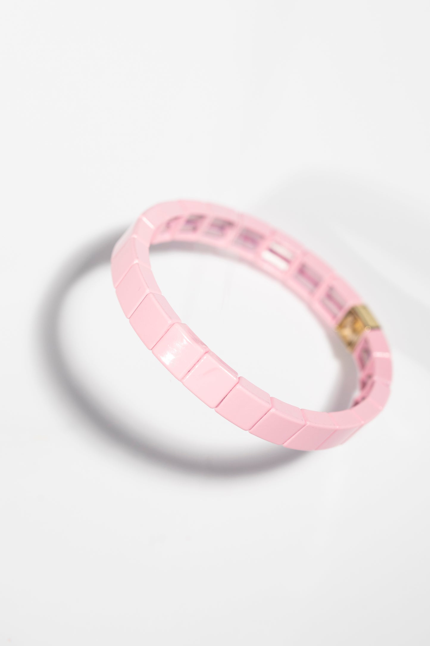 Minimalist pink tile bracelet with glossy finish, angled view on white background