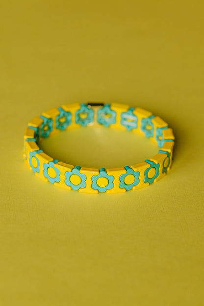 Retro daisy bracelet with yellow tiles and mint green flowers on yellow surface