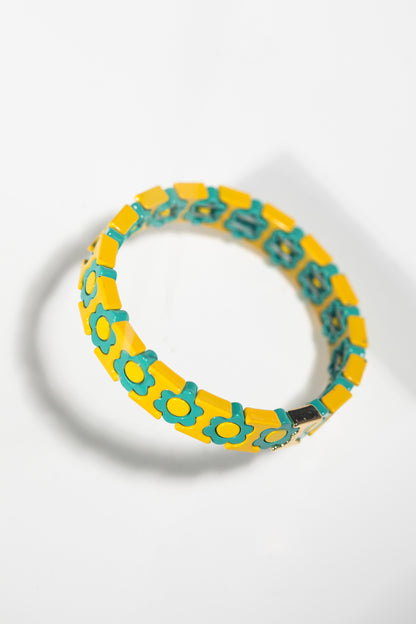 Yellow tile bracelet with turquoise flower pattern photographed at angle on white background